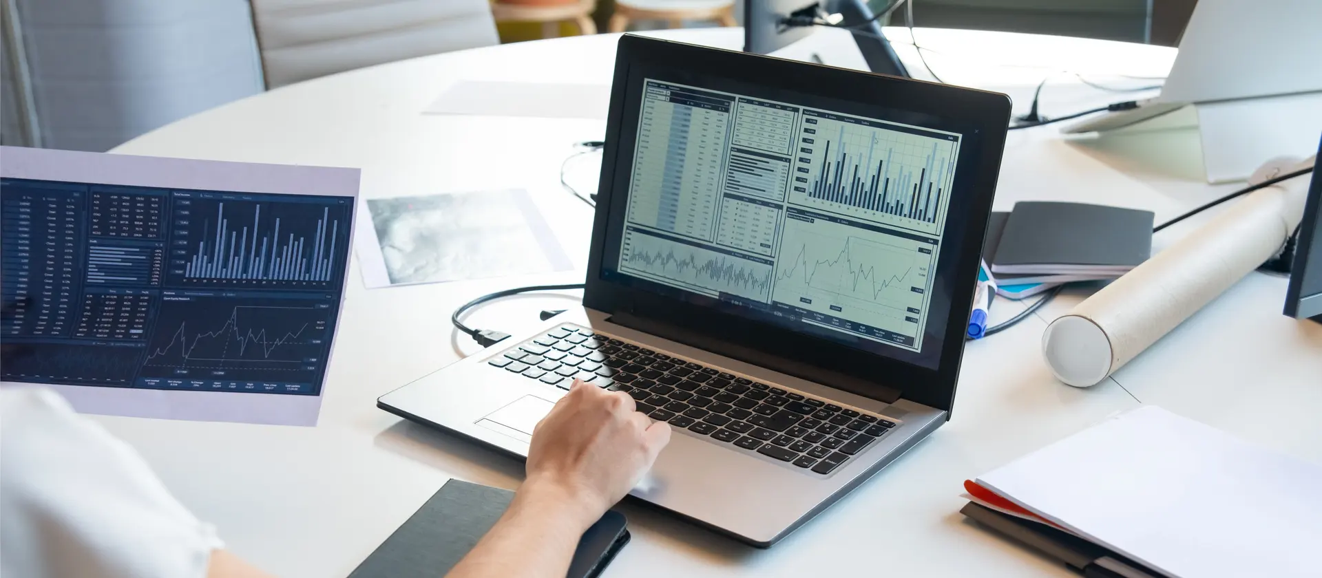 Professional analyzing financial data and charts on a laptop