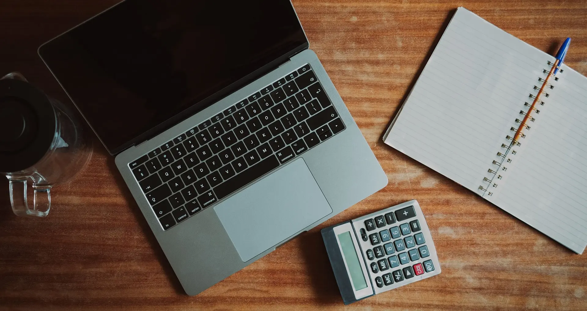 Laptop, notebook, and calculator used to organize employer registration records